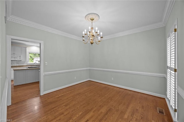 1400 Covered Wagon Rd, Mcleansville, NC 27301 - unfurnished room with ornamental molding, wood finished floors, a chandelier, and baseboards