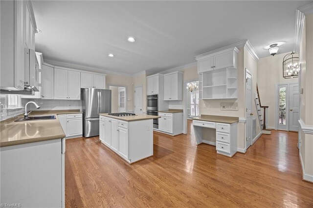 1400 Covered Wagon Rd, Mcleansville, NC 27301 - kitchen featuring appliances with stainless steel finishes, a sink, a chandelier, white cabinets, and ornamental molding