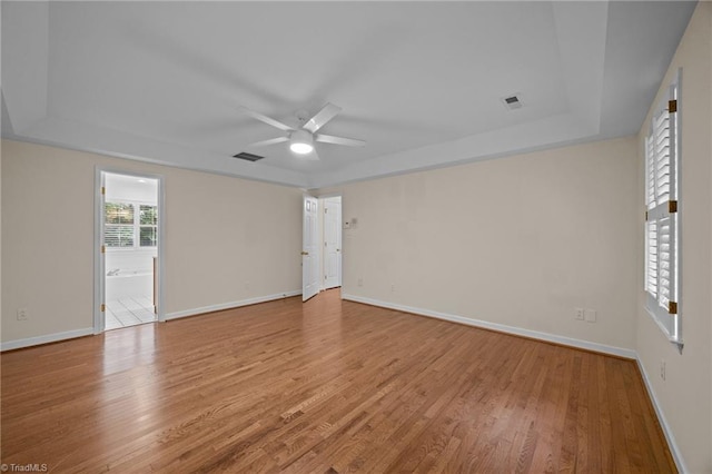 1400 Covered Wagon Rd, Mcleansville, NC 27301 - unfurnished room featuring a tray ceiling, a ceiling fan, light wood-type flooring, and baseboards