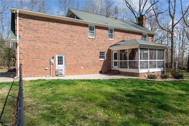 1400 Covered Wagon Rd, Mcleansville, NC 27301 - rear view of property featuring a sunroom, a chimney, a patio, a yard, and brick siding