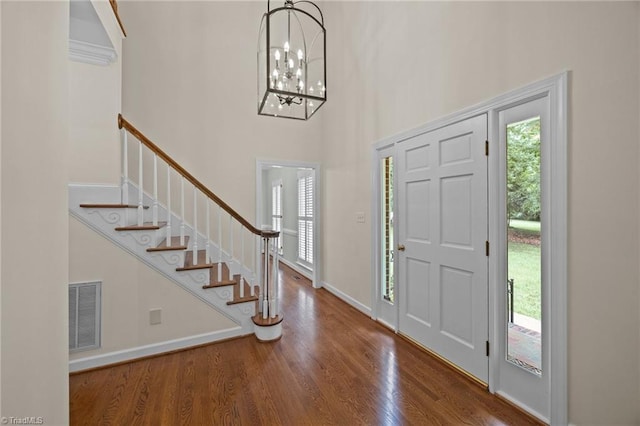 1400 Covered Wagon Rd, Mcleansville, NC 27301 - entryway featuring a towering ceiling, stairway, wood finished floors, a chandelier, and baseboards