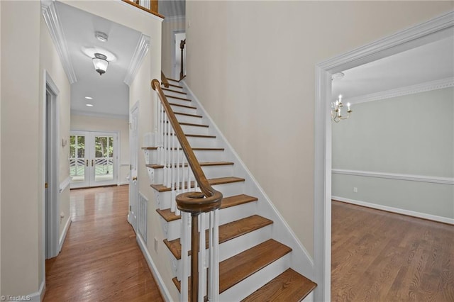 1400 Covered Wagon Rd, Mcleansville, NC 27301 - staircase featuring crown molding, wood finished floors, french doors, baseboards, and a chandelier