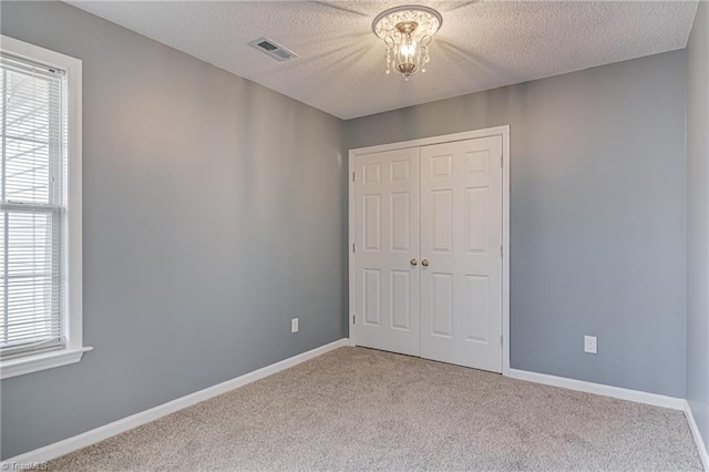 unfurnished bedroom featuring visible vents, baseboards, a closet, and carpet floors