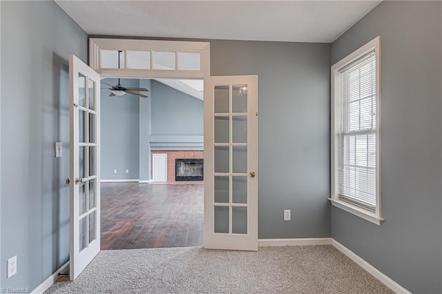 spare room with a ceiling fan, carpet flooring, french doors, and baseboards