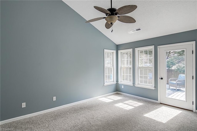 carpeted empty room with visible vents, a textured ceiling, baseboards, ceiling fan, and vaulted ceiling