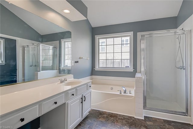 full bathroom with a garden tub, stone finish floor, a shower stall, vanity, and vaulted ceiling