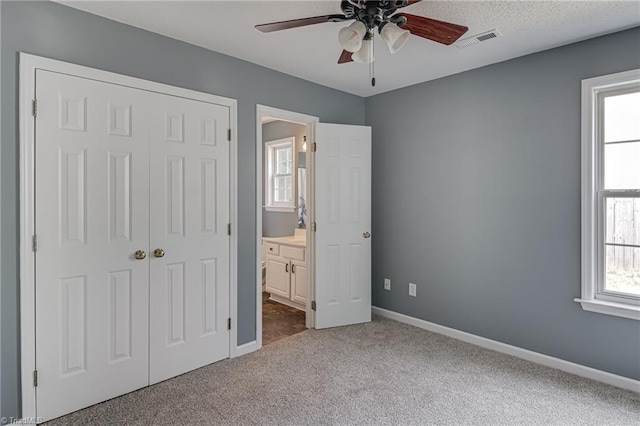 unfurnished bedroom featuring visible vents, baseboards, a closet, and carpet flooring