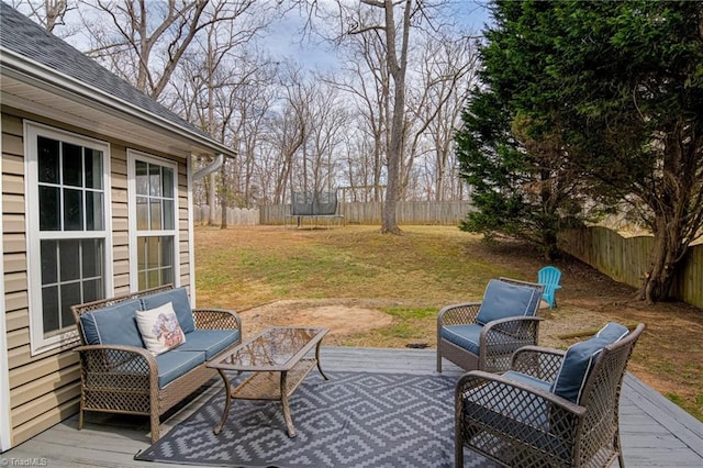 view of patio / terrace featuring a deck, an outdoor living space, a fenced backyard, and a trampoline