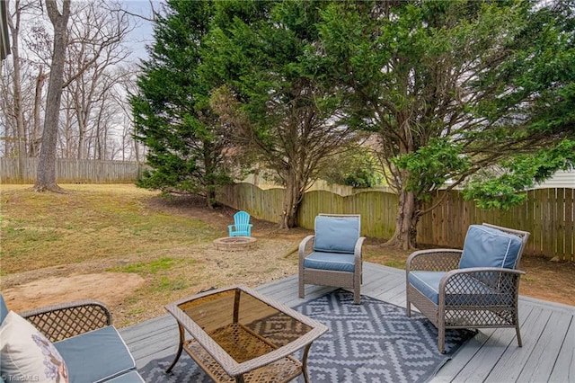 wooden terrace with a fenced backyard and an outdoor fire pit