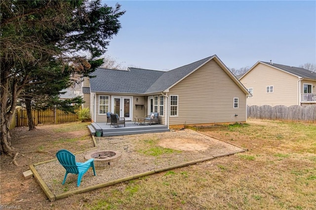 back of house featuring a wooden deck, french doors, an outdoor fire pit, and a fenced backyard