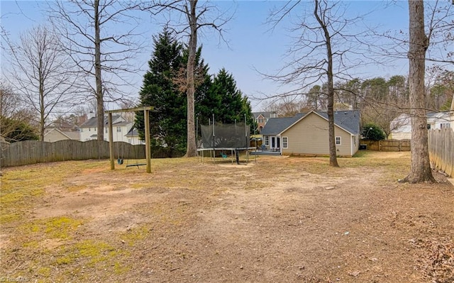 view of yard featuring a trampoline and a fenced backyard