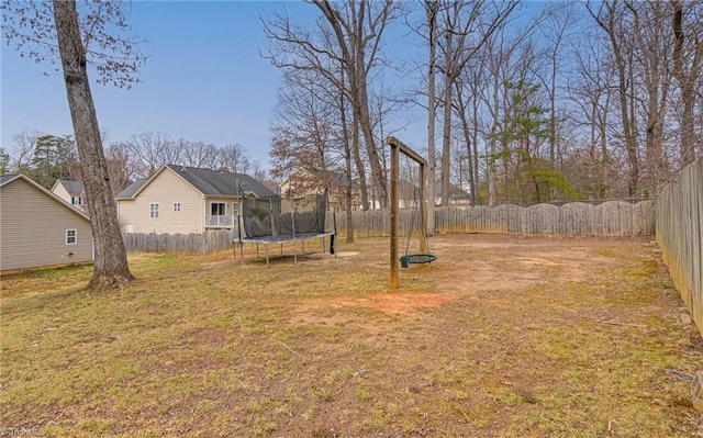 view of yard featuring a trampoline and a fenced backyard