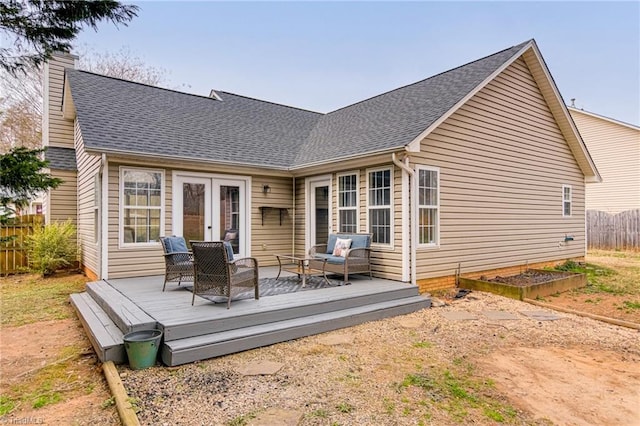 rear view of house featuring a vegetable garden, a chimney, a deck, and fence