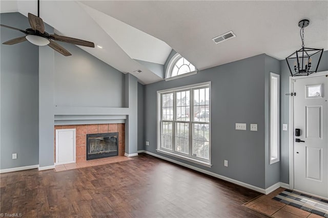 unfurnished living room with visible vents, baseboards, lofted ceiling, and wood finished floors