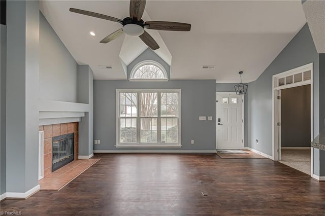 unfurnished living room with visible vents, a tile fireplace, a ceiling fan, and vaulted ceiling