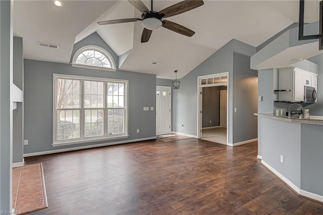 unfurnished living room with visible vents, baseboards, dark wood finished floors, lofted ceiling, and a ceiling fan