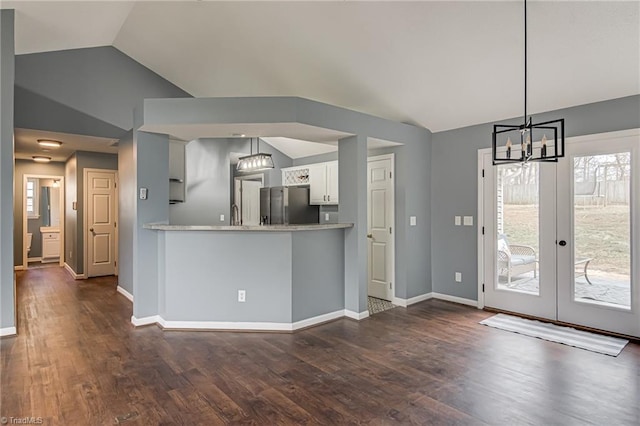 kitchen featuring dark wood-type flooring, baseboards, stainless steel fridge with ice dispenser, lofted ceiling, and a notable chandelier