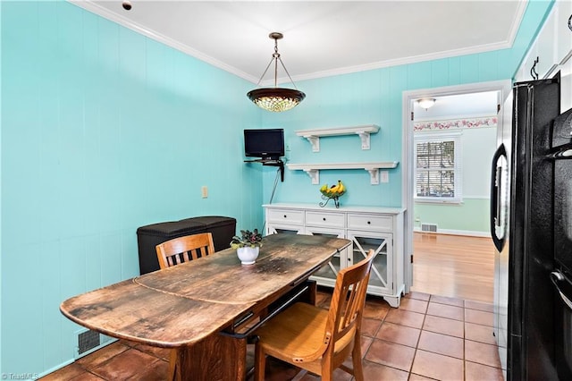 dining area featuring light tile patterned floors and ornamental molding