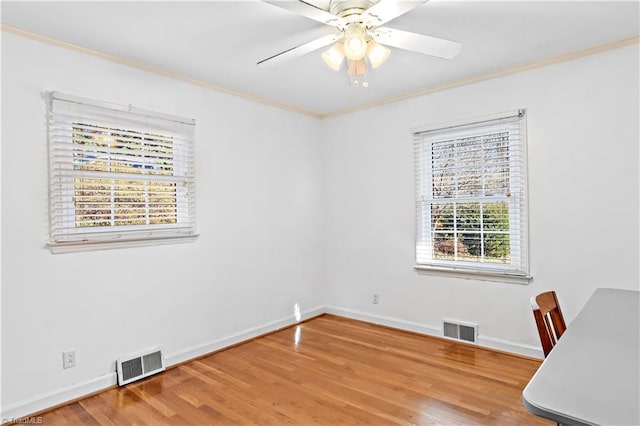 unfurnished office with ceiling fan, wood-type flooring, and ornamental molding