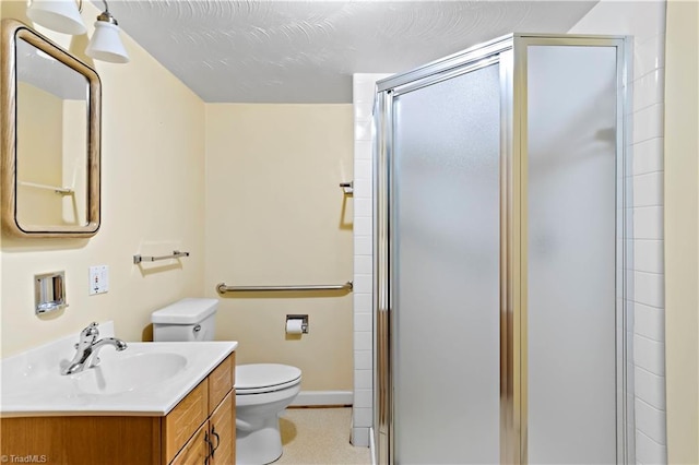 bathroom with vanity, toilet, and a shower with door