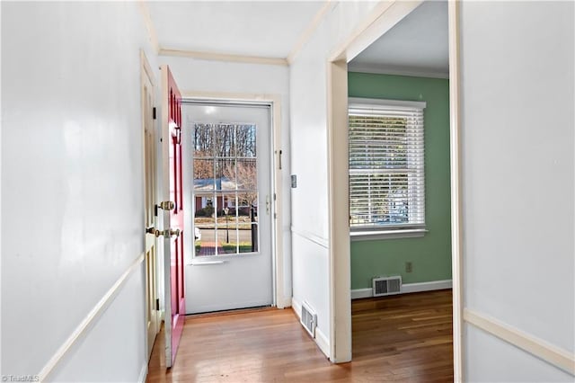 entryway featuring crown molding and light hardwood / wood-style flooring