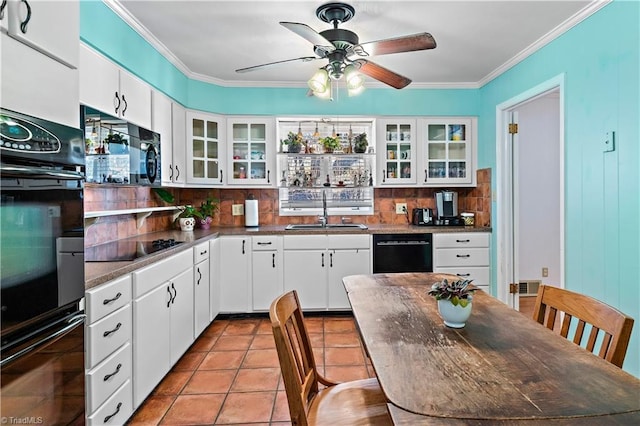 kitchen with backsplash, white cabinetry, black appliances, and sink