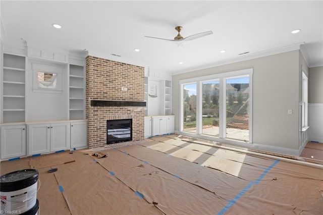 unfurnished living room featuring built in features, a ceiling fan, crown molding, a brick fireplace, and recessed lighting