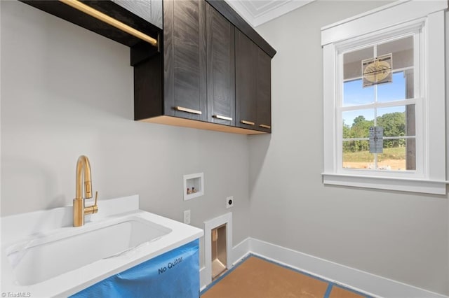 clothes washing area featuring hookup for a washing machine, hookup for an electric dryer, a sink, baseboards, and cabinet space