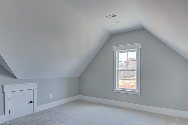 bonus room with visible vents, vaulted ceiling, light carpet, and baseboards