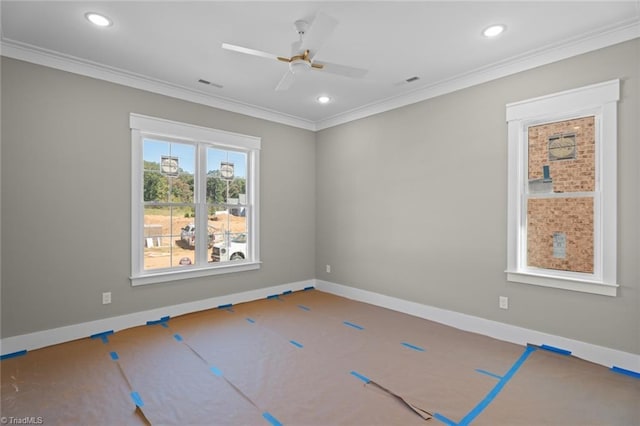 empty room featuring baseboards, visible vents, and crown molding