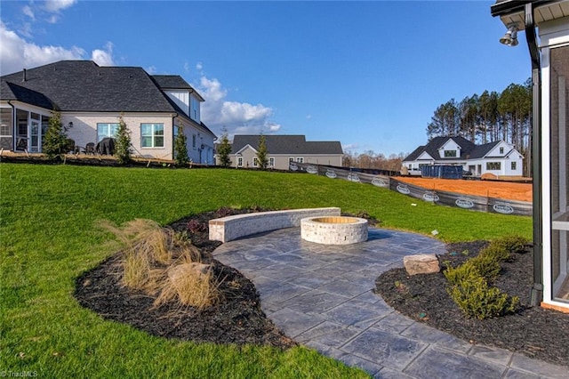 view of yard with an outdoor fire pit, a patio area, and a residential view