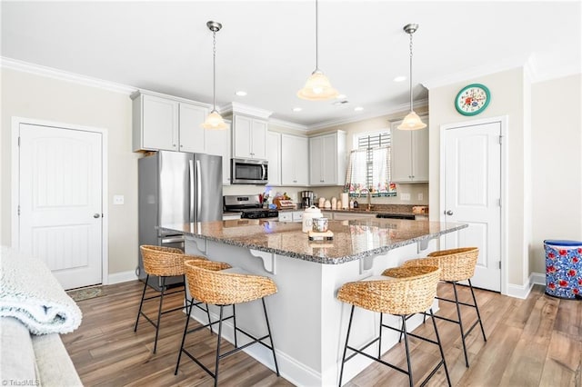 2177 Campbell Loop, Burlington, NC 27215 - kitchen with stainless steel appliances, ornamental molding, a breakfast bar area, a sink, and baseboards