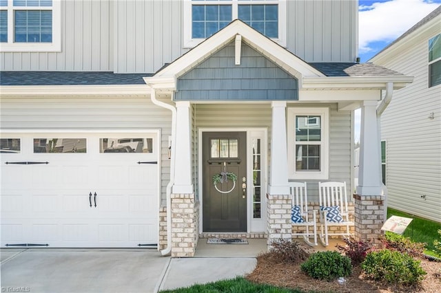 2177 Campbell Loop, Burlington, NC 27215 - view of exterior entry featuring covered porch, board and batten siding, driveway, stone siding, and a garage