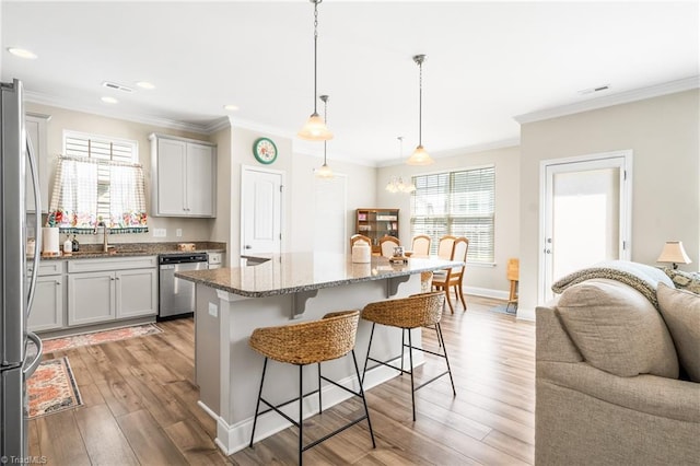 2177 Campbell Loop, Burlington, NC 27215 - kitchen with stainless steel appliances, a kitchen bar, a sink, crown molding, and stone countertops