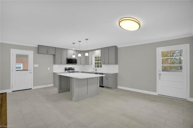 kitchen with sink, hanging light fixtures, appliances with stainless steel finishes, gray cabinets, and a kitchen island