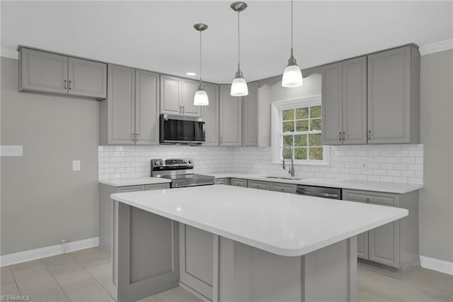 kitchen with sink, tasteful backsplash, decorative light fixtures, a kitchen island, and stainless steel appliances