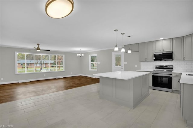 kitchen with gray cabinets, backsplash, stainless steel range with electric stovetop, hanging light fixtures, and a center island