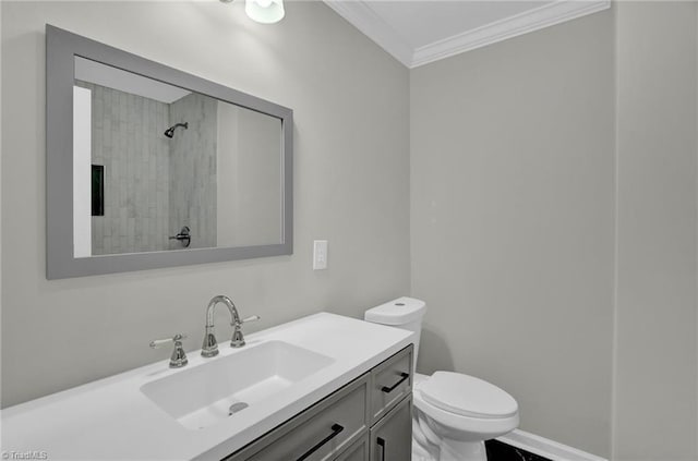 bathroom with ornamental molding, tiled shower, vanity, and toilet