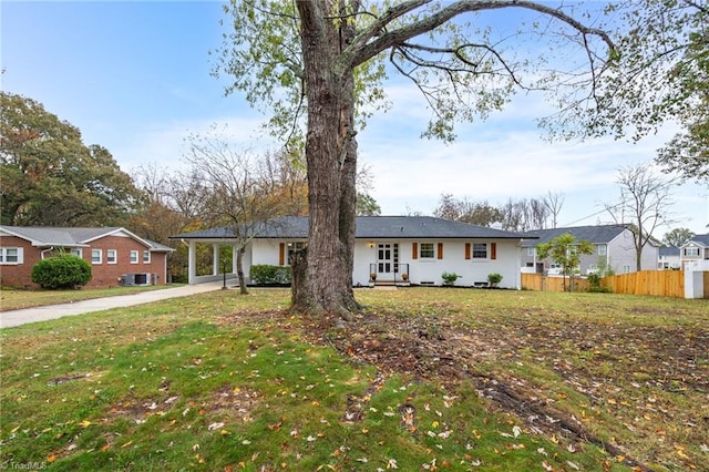 ranch-style house featuring a carport, a front yard, and central air condition unit