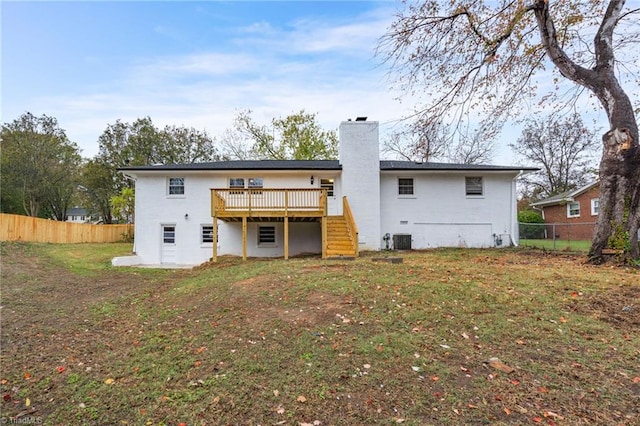 rear view of house featuring central AC unit, a yard, and a deck