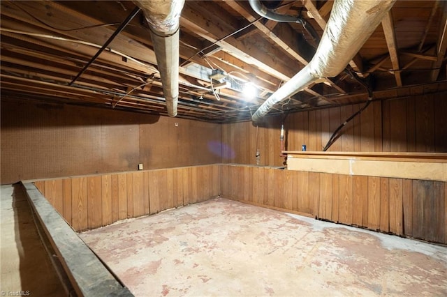 basement featuring wooden walls