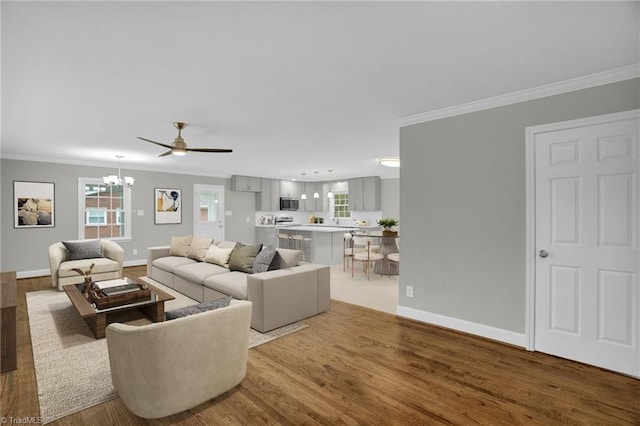 living room with ornamental molding, plenty of natural light, and light hardwood / wood-style flooring