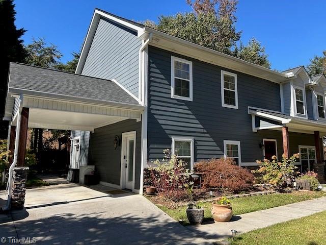 view of front of house featuring concrete driveway and roof with shingles