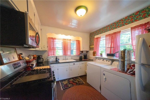 laundry area with sink, washer and dryer, and a healthy amount of sunlight