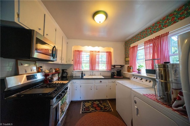 kitchen featuring stainless steel appliances, white cabinetry, independent washer and dryer, and sink