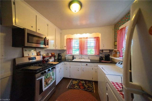 kitchen with appliances with stainless steel finishes, decorative backsplash, white cabinetry, sink, and washing machine and clothes dryer