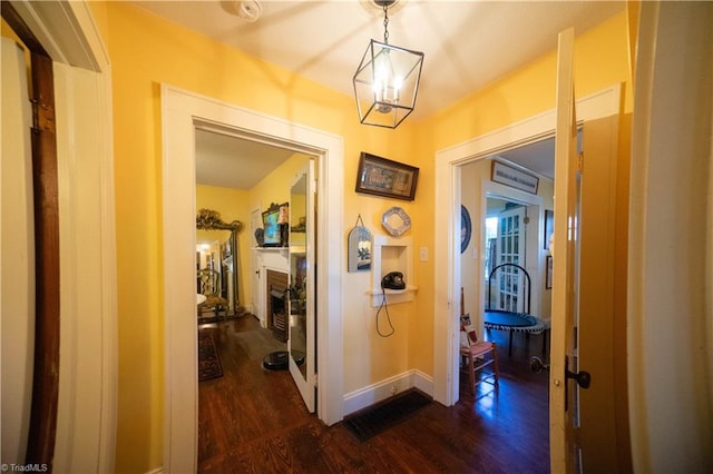 hall with dark hardwood / wood-style flooring and a chandelier