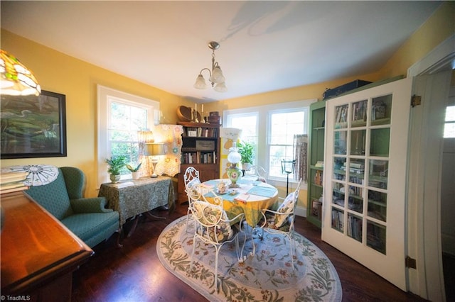 dining area featuring a notable chandelier, dark hardwood / wood-style flooring, and a wealth of natural light