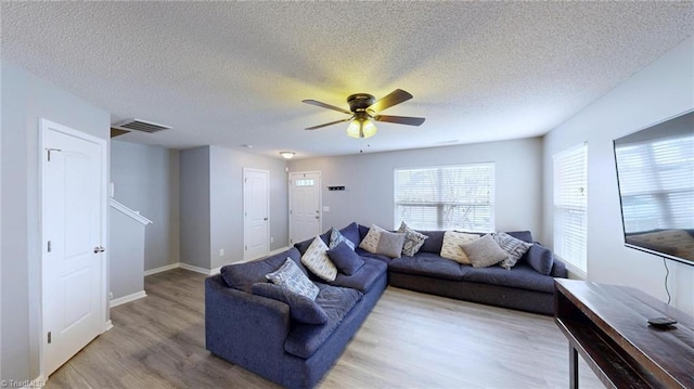 living room featuring hardwood / wood-style flooring, a textured ceiling, and ceiling fan