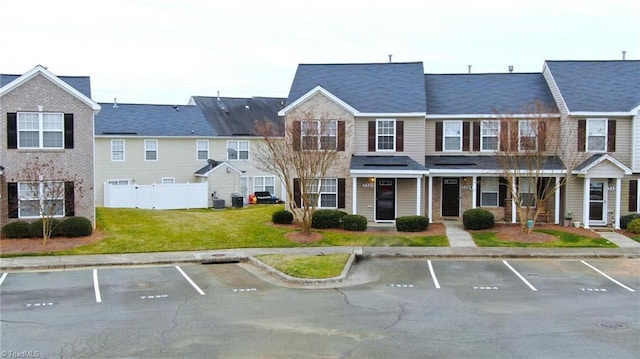 exterior space featuring central air condition unit and a front lawn